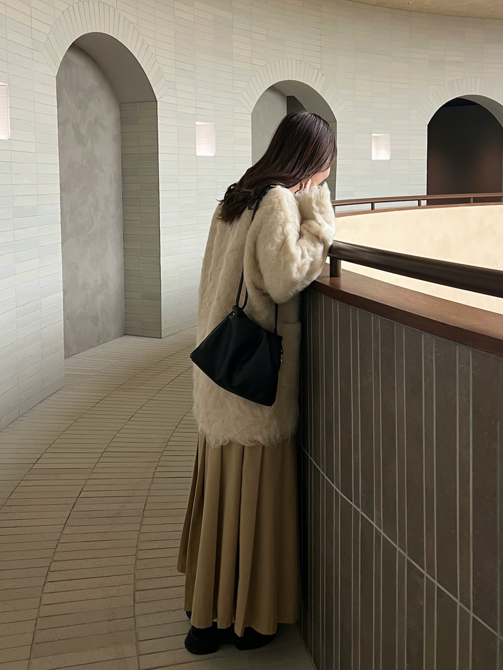 ホワイト系のカーディガン/ボレロ、ベージュ系のスカート、ブラック系のローファーを着用したレディースの秋コーディネートの2枚目の写真