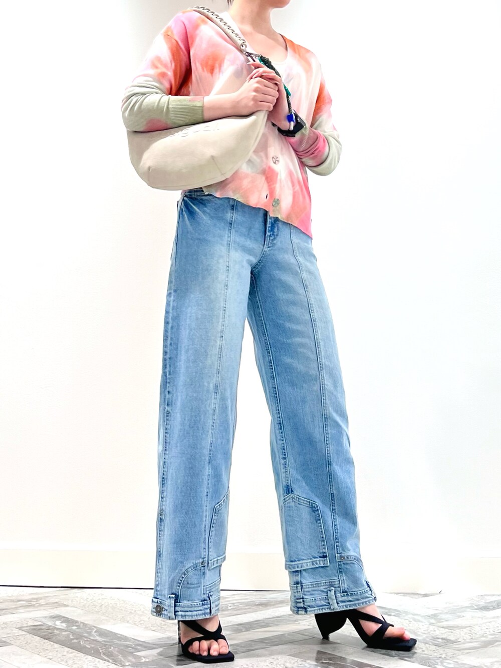 ホワイト系のカーディガン/ボレロ、ホワイト系のTシャツ/カットソー、ブルー系のデニムパンツを着用したレディースの夏コーディネートの2枚目の写真