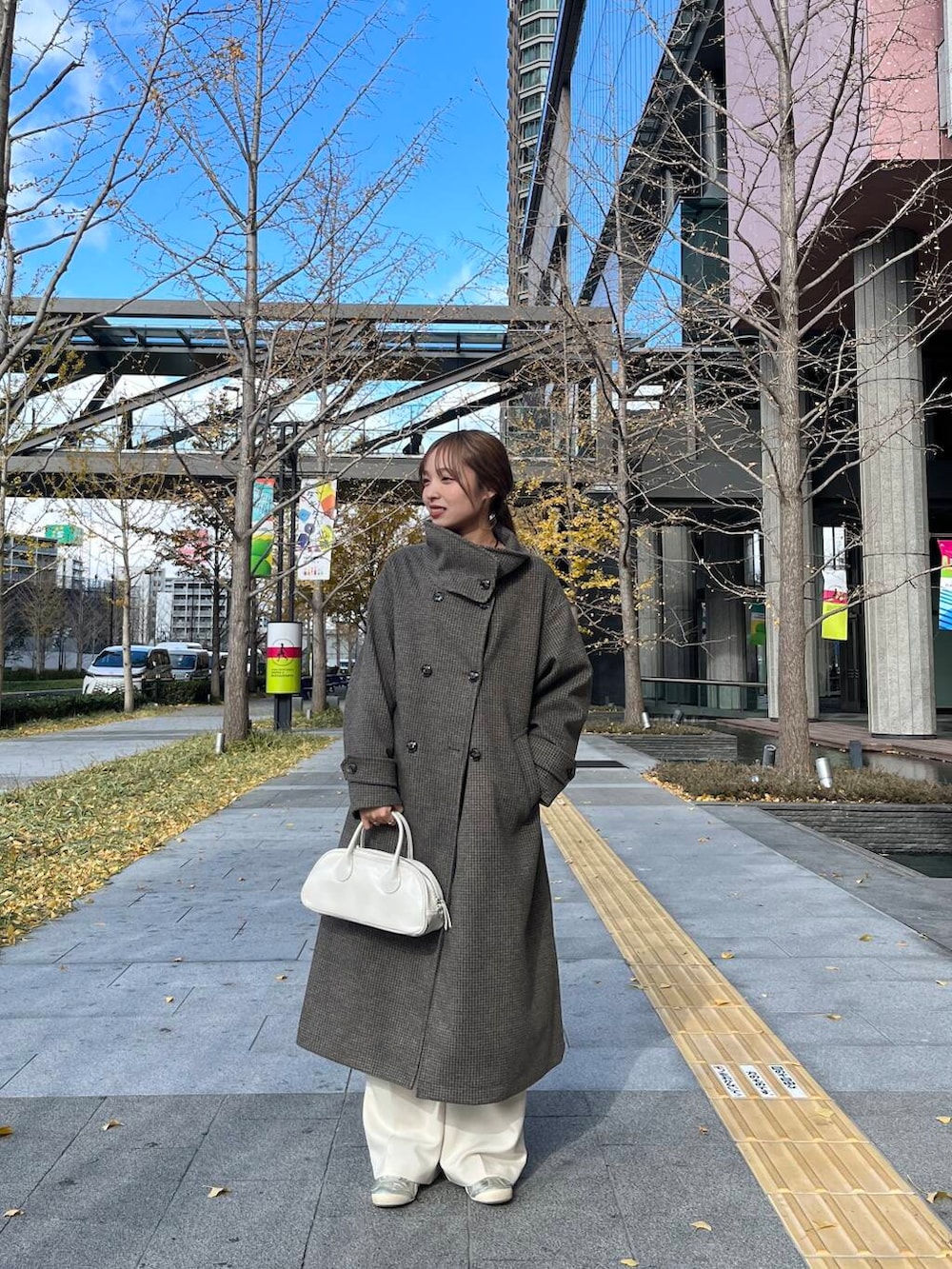 ブラウン系のその他アウター、ホワイト系のその他パンツ、ホワイト系のボストンバッグを着用したレディースの冬コーディネートの2枚目の写真