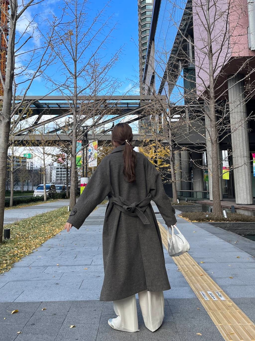 ブラウン系のその他アウター、ホワイト系のその他パンツ、ホワイト系のボストンバッグを着用したレディースの冬コーディネートの3枚目の写真