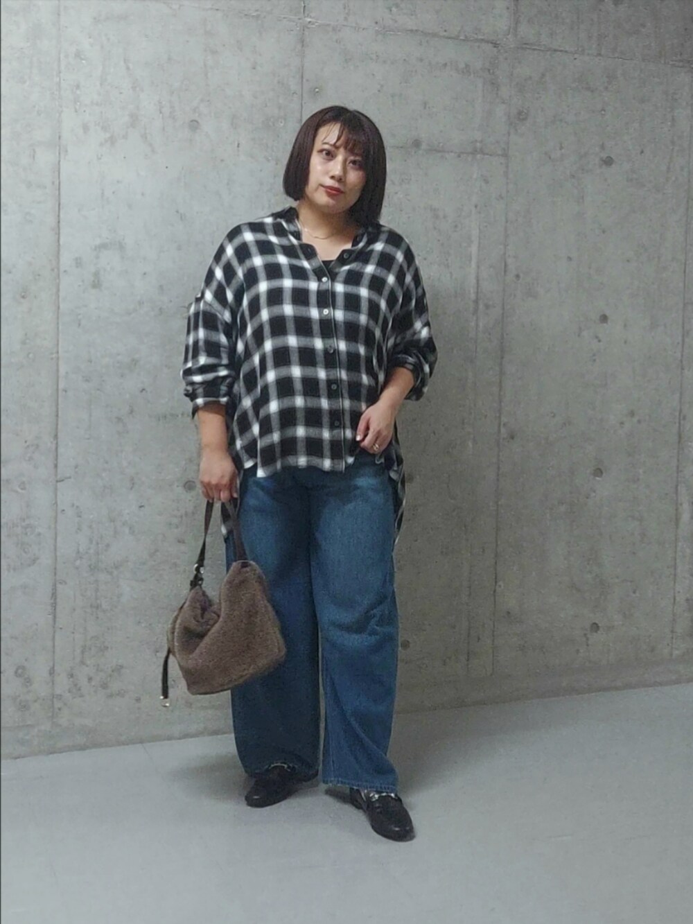 ブラック系のシャツ/ブラウス、ブルー系のデニムパンツ、ブラック系のローファーを着用したレディースの秋コーディネートの3枚目の写真