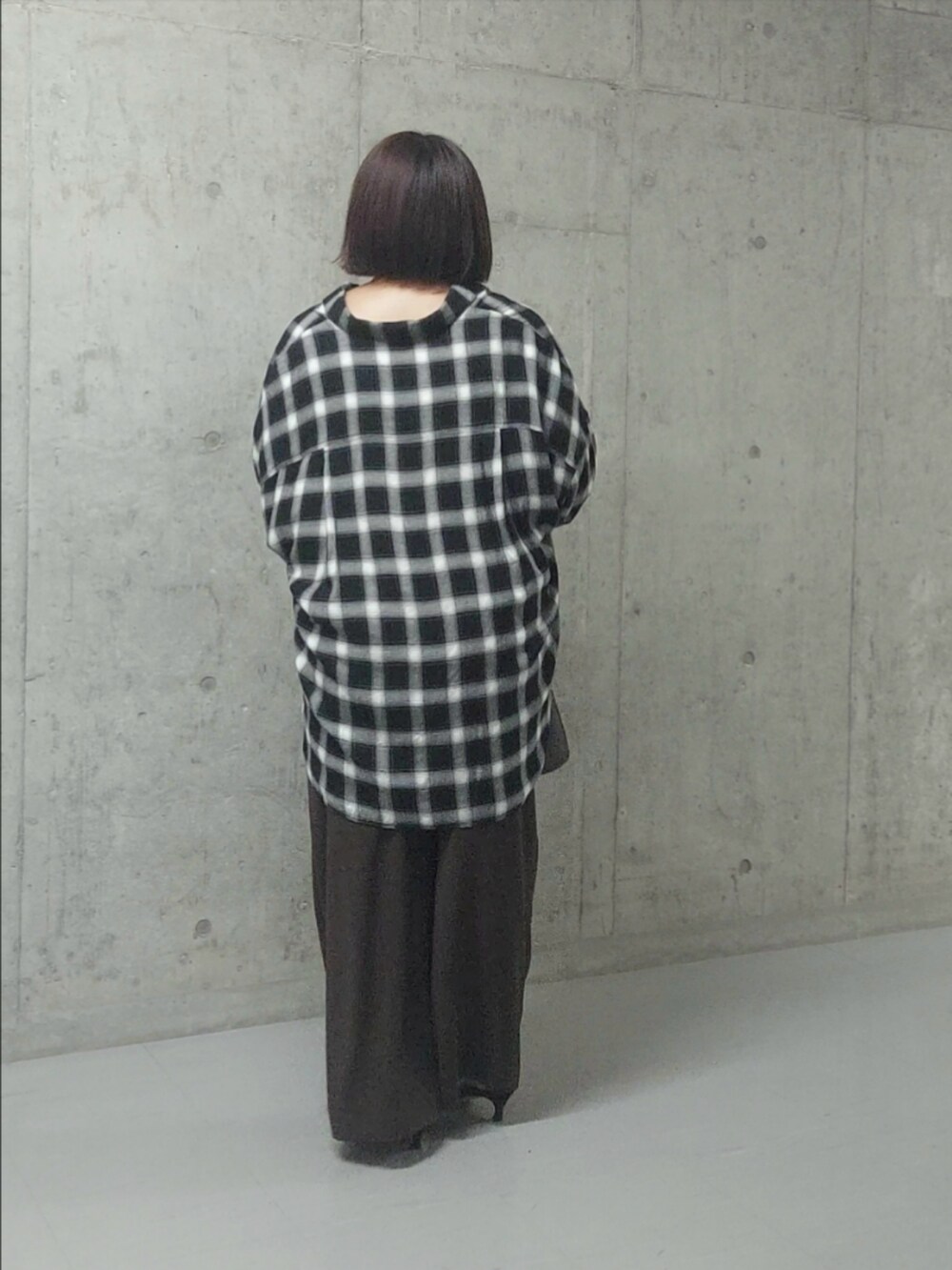 ブラック系のシャツ/ブラウス、ブラウン系のスラックス、ブラック系のパンプスを着用したレディースの秋コーディネートの2枚目の写真