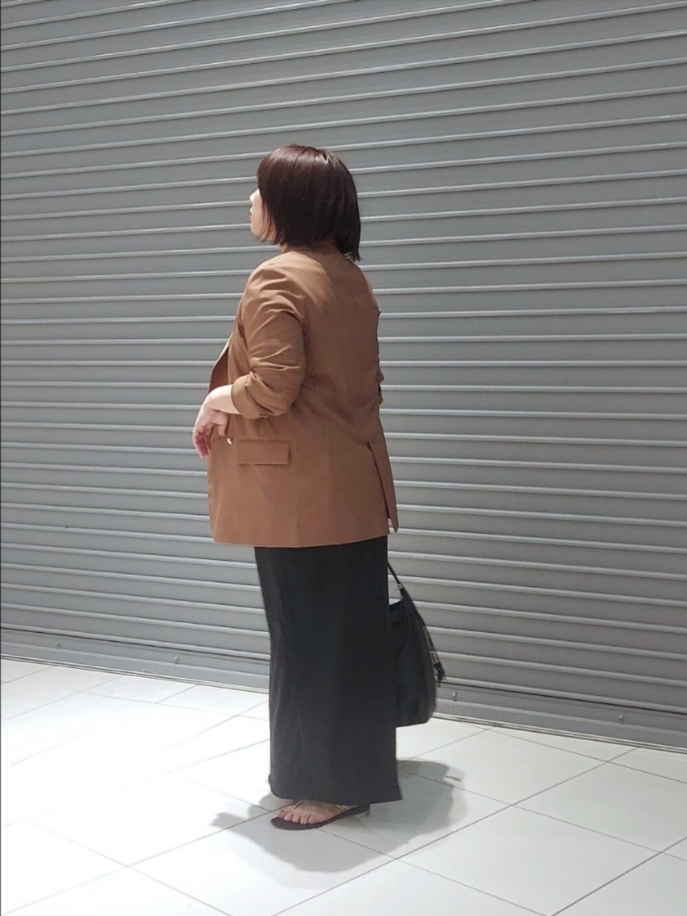 ブラウン系のテーラードジャケット、ブラック系のワンピースを着用したレディースの夏コーディネートの3枚目の写真