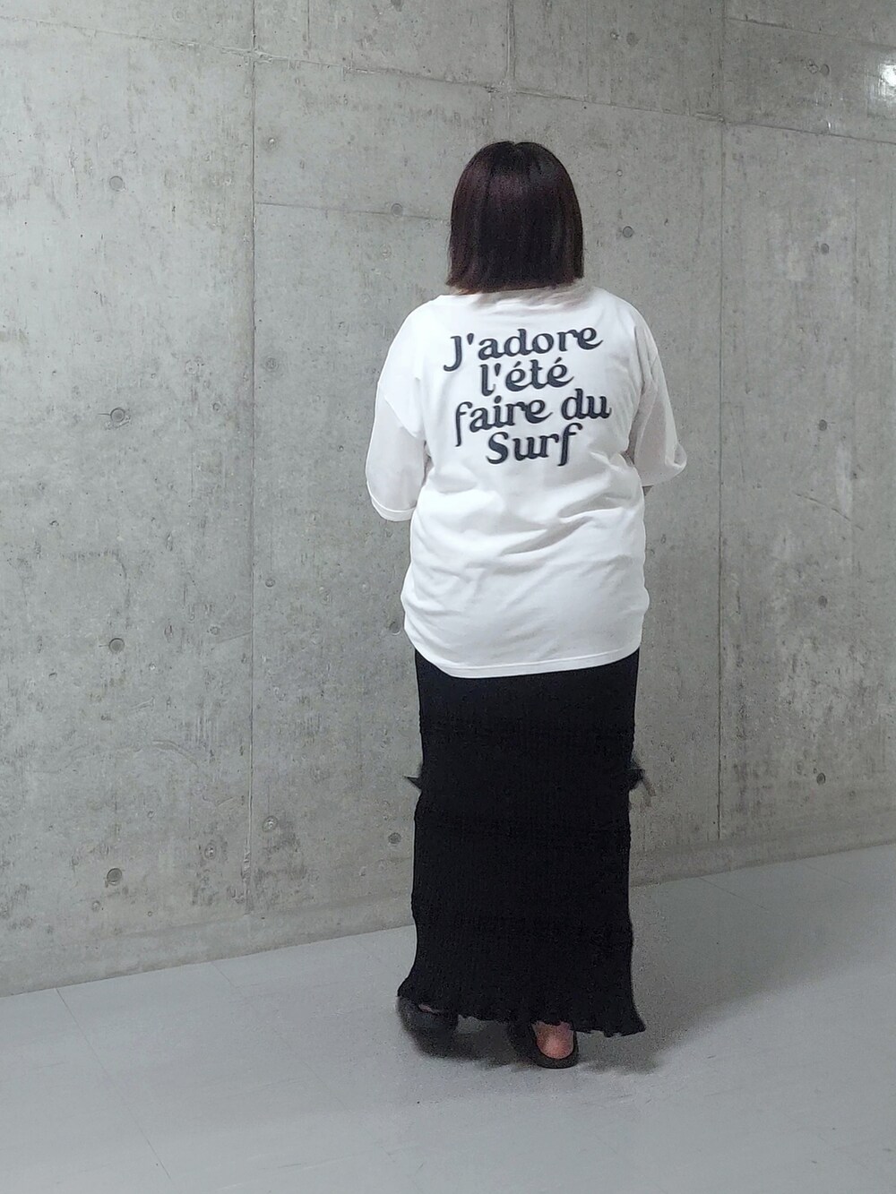 ホワイト系のTシャツ/カットソー、ブラック系のハンドバッグ、ブラック系のサンダルを着用したレディースの夏コーディネートの2枚目の写真