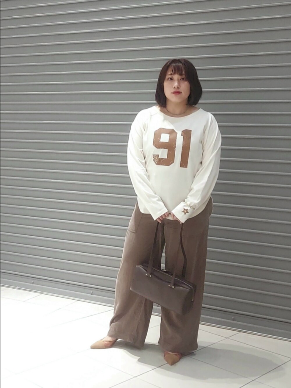 ホワイト系のTシャツ/カットソー、ブラウン系のその他パンツ、ブラウン系のショルダーバッグを着用したレディースの秋コーディネートの3枚目の写真