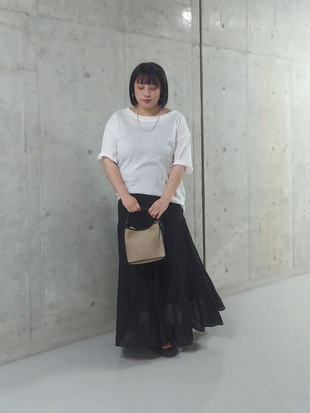 ホワイト系のTシャツ/カットソー、ブラック系のスカート、ブラック系のハンドバッグを着用したレディースの夏コーディネートの3枚目の写真