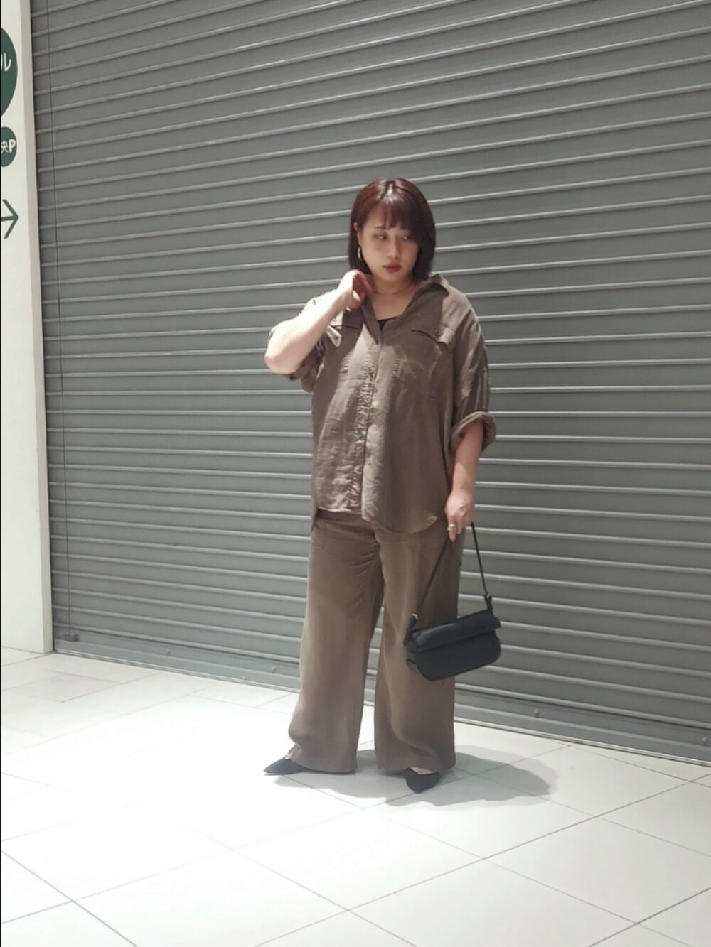 ブラウン系のシャツ/ブラウス、グレー系のその他パンツ、ブラック系のパンプスを着用したレディースの夏コーディネートの2枚目の写真
