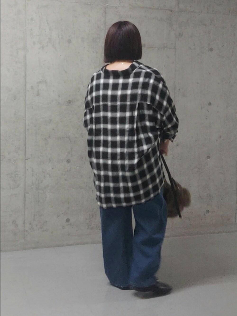 ブラック系のシャツ/ブラウス、ブルー系のデニムパンツ、ブラック系のローファーを着用したレディースの秋コーディネートの2枚目の写真