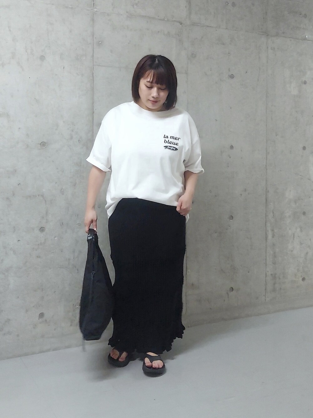 ホワイト系のTシャツ/カットソー、ブラック系のハンドバッグ、ブラック系のサンダルを着用したレディースの夏コーディネートの3枚目の写真