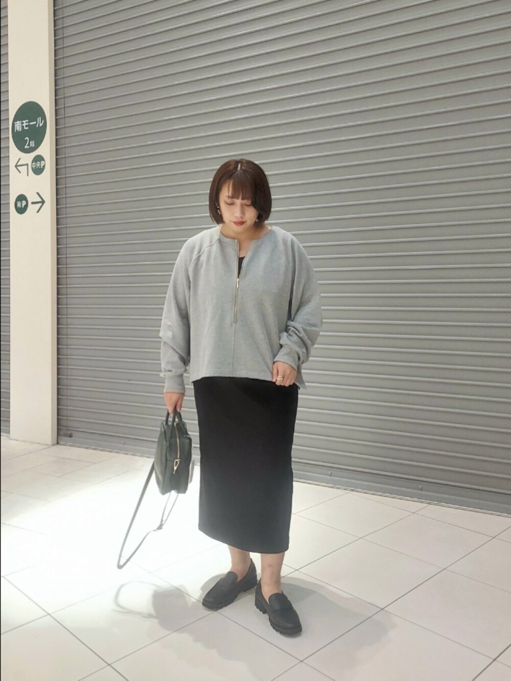 グレー系のスウェット、ブラック系のワンピースを着用したレディースの秋コーディネートの3枚目の写真