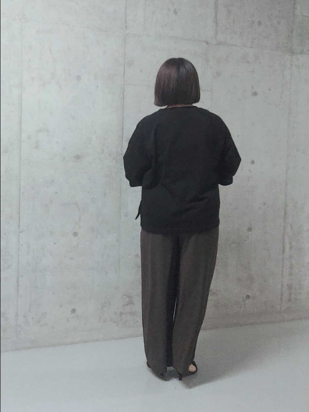 ブラック系のスウェット、レッド系のスラックス、ブラック系のパンプスを着用したレディースの秋コーディネートの2枚目の写真