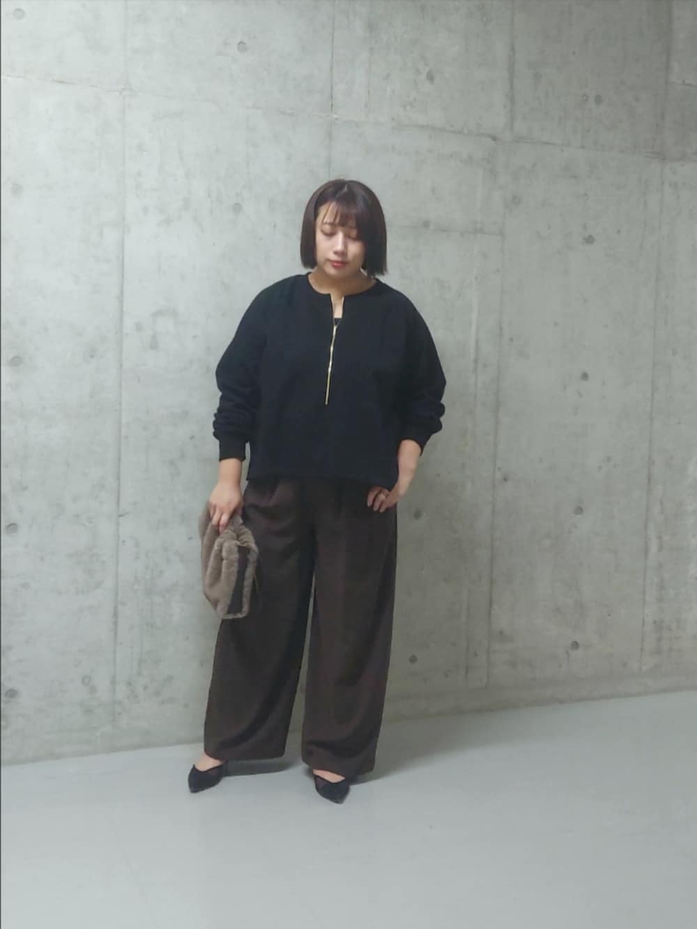 ブラック系のスウェット、レッド系のスラックス、ブラック系のパンプスを着用したレディースの秋コーディネートの3枚目の写真