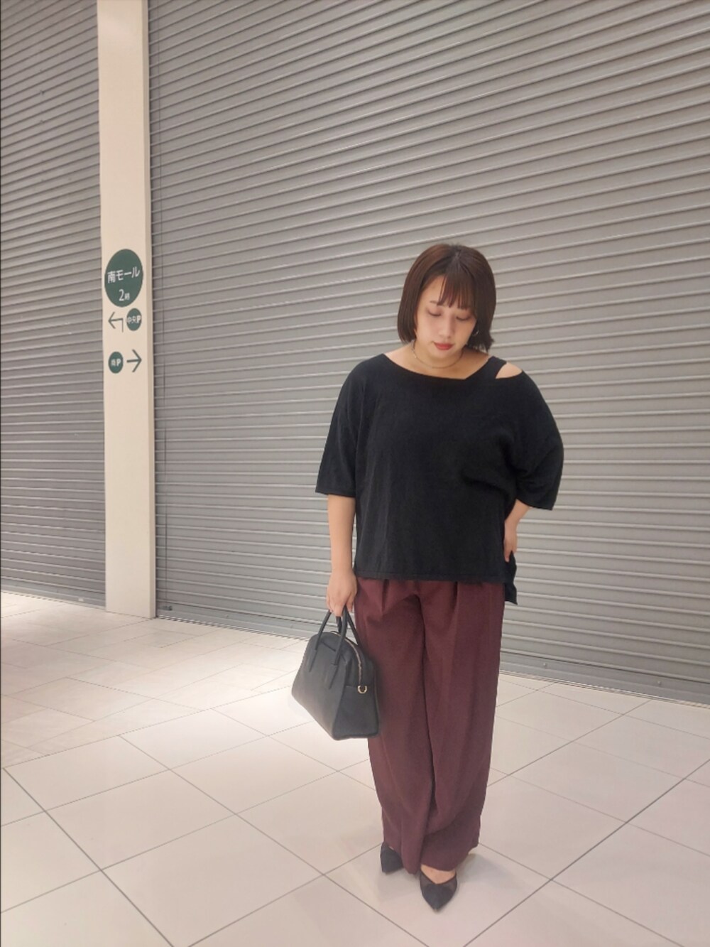 ブラック系のニット/セーター、レッド系のスラックス、ブラック系のパンプスを着用したレディースの夏コーディネートの3枚目の写真