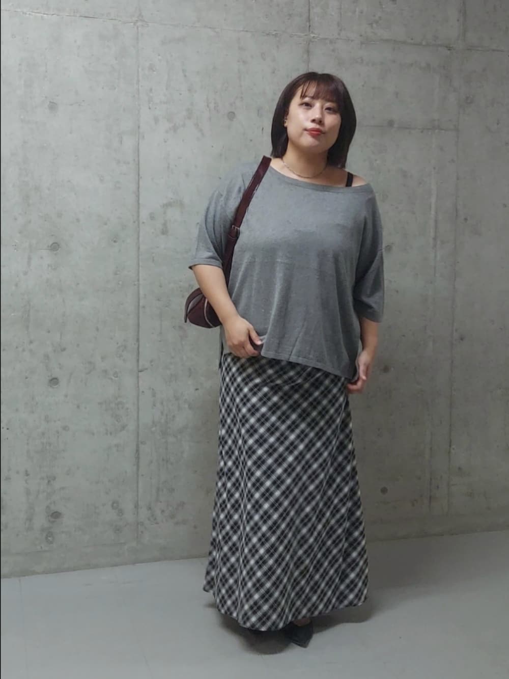 ブラック系のニット/セーター、ブラック系のスカート、ブラック系のパンプスを着用したレディースの夏コーディネートの3枚目の写真