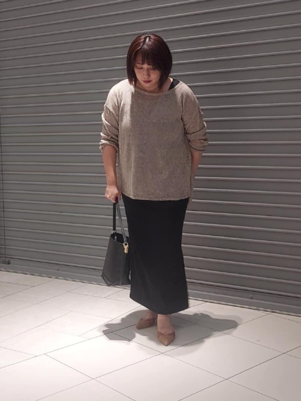 ブラウン系のニット/セーター、ブラック系のワンピース、ブラウン系のパンプスを着用したレディースの夏コーディネートの3枚目の写真