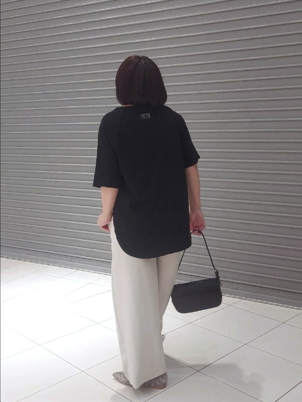 ブラウン系のTシャツ/カットソー、グレー系のスラックス、グレー系のパンプスを着用したレディースの夏コーディネートの2枚目の写真