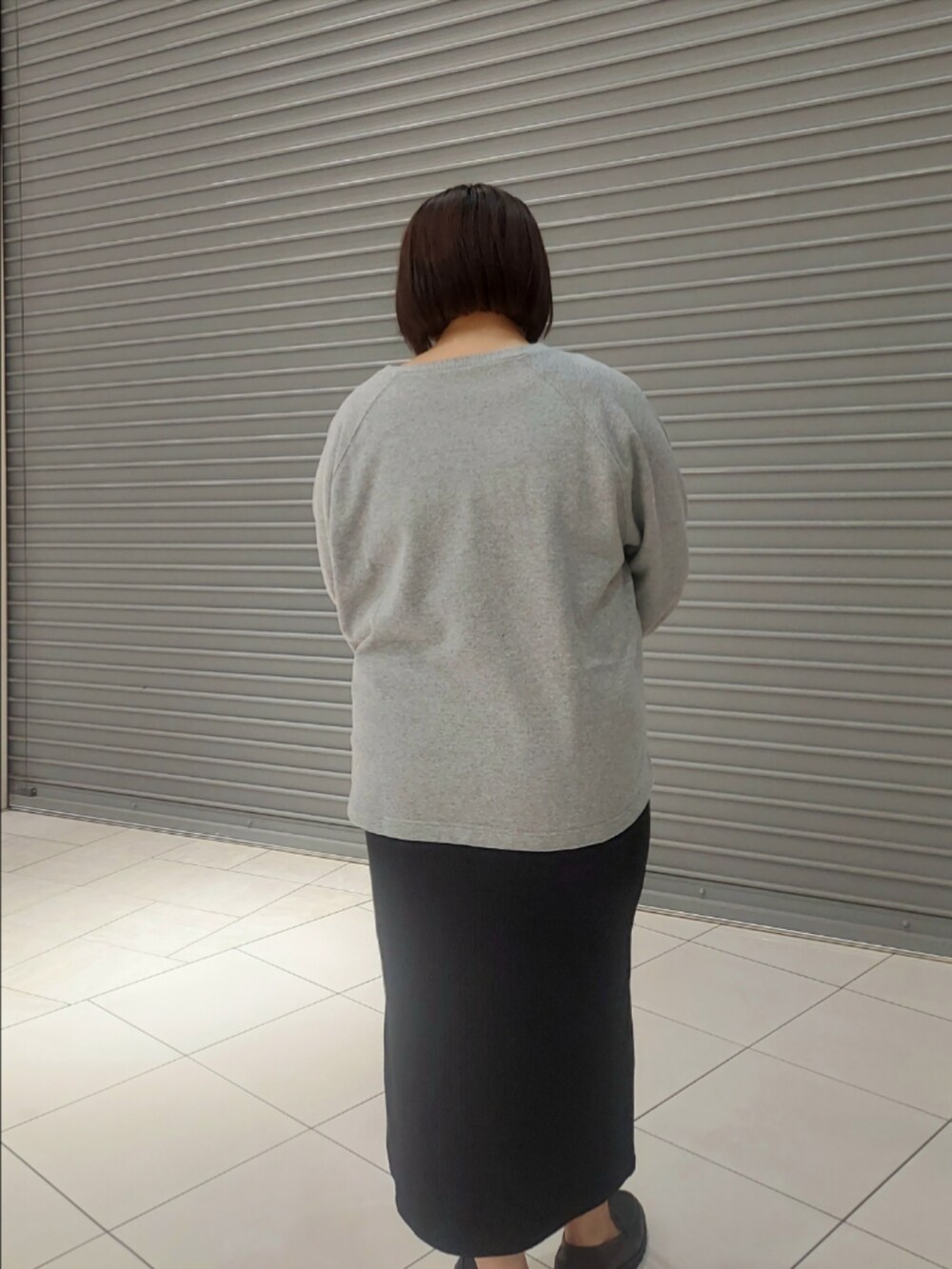 グレー系のスウェット、ブラック系のワンピースを着用したレディースの秋コーディネートの2枚目の写真