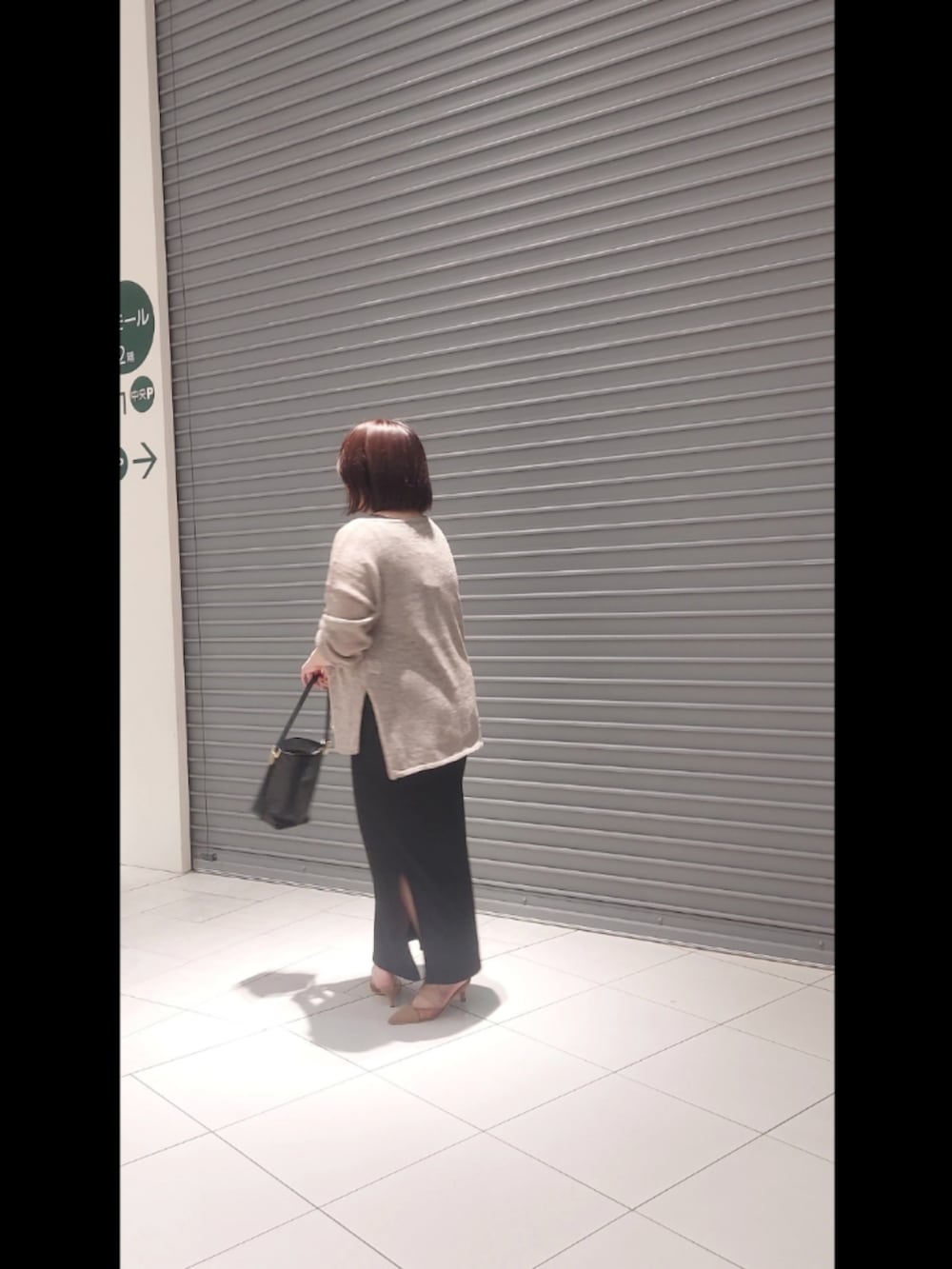 ブラウン系のニット/セーター、ブラック系のワンピース、ブラウン系のパンプスを着用したレディースの夏コーディネートの2枚目の写真