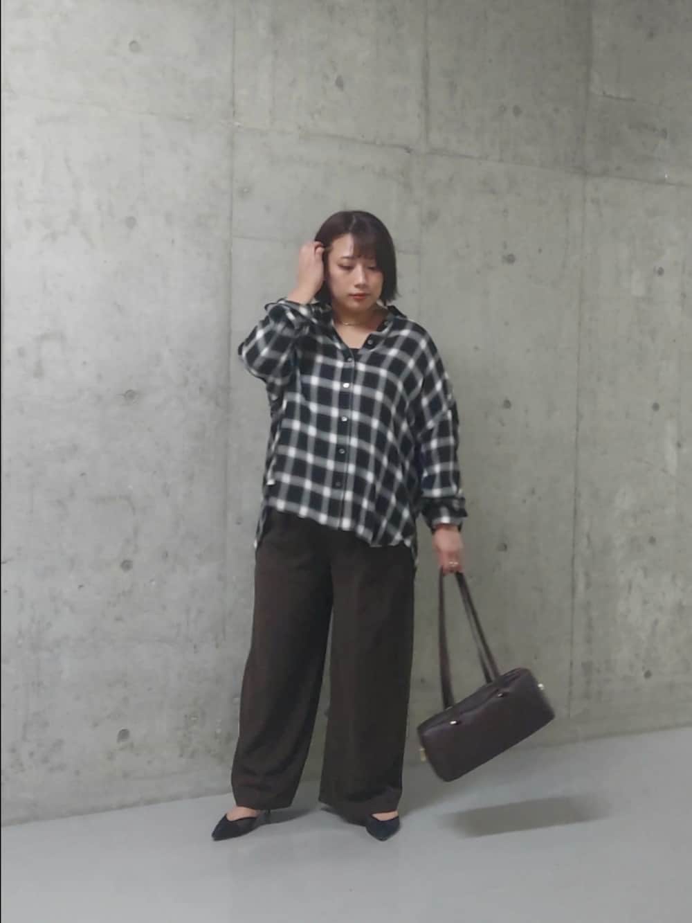 ブラック系のシャツ/ブラウス、ブラウン系のスラックス、ブラック系のパンプスを着用したレディースの秋コーディネートの3枚目の写真