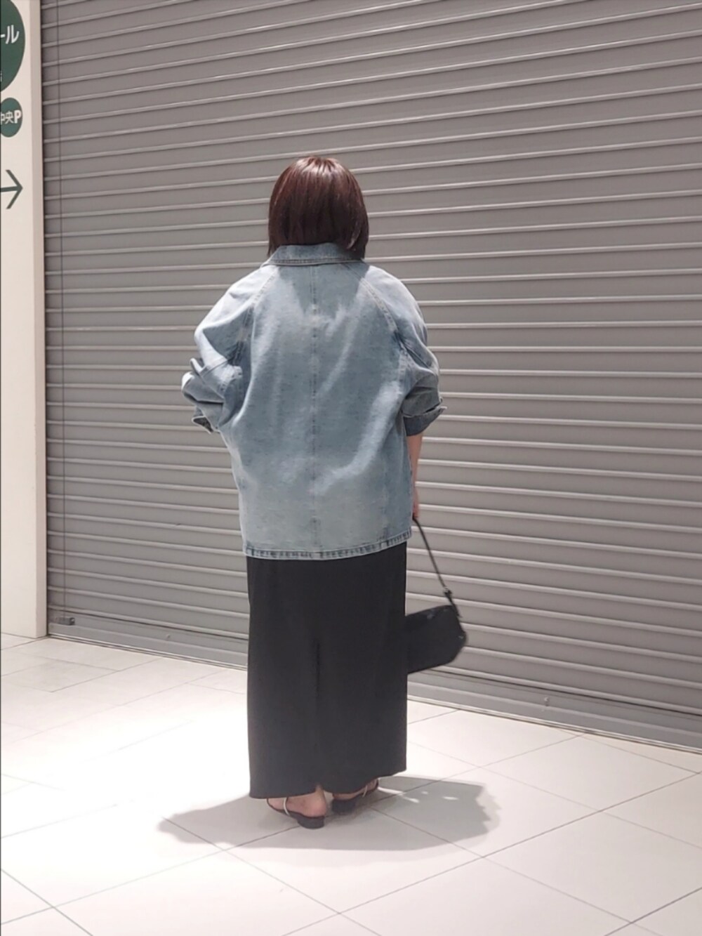 ブルー系のデニムジャケット、ブラック系のワンピースを着用したレディースの夏コーディネートの2枚目の写真
