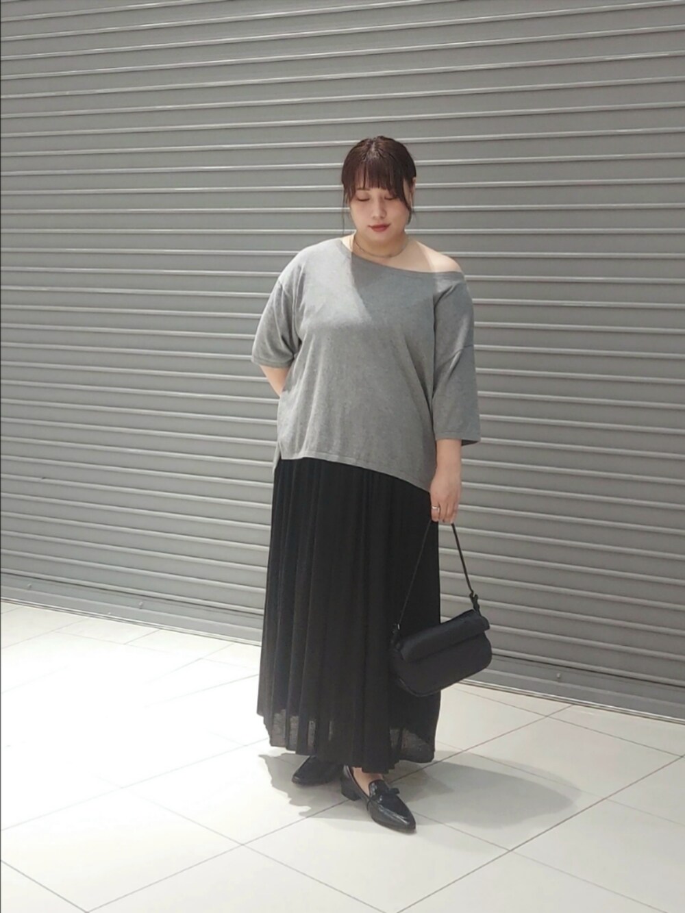 ブラック系のニット/セーター、ブラック系のスカートを着用したレディースの秋コーディネートの3枚目の写真