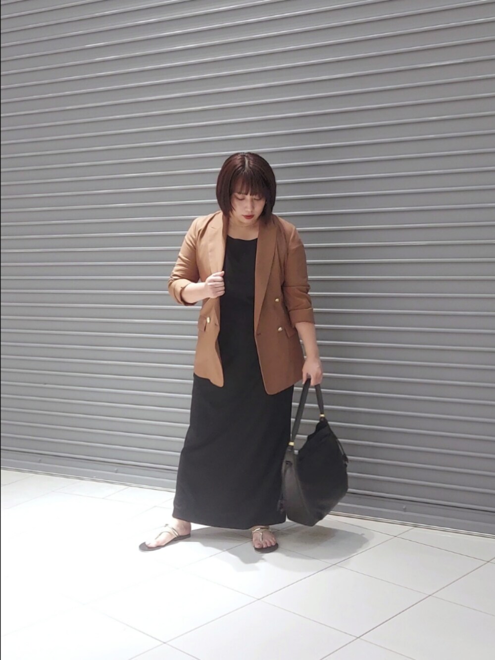 ブラウン系のテーラードジャケット、ブラック系のワンピースを着用したレディースの夏コーディネートの2枚目の写真