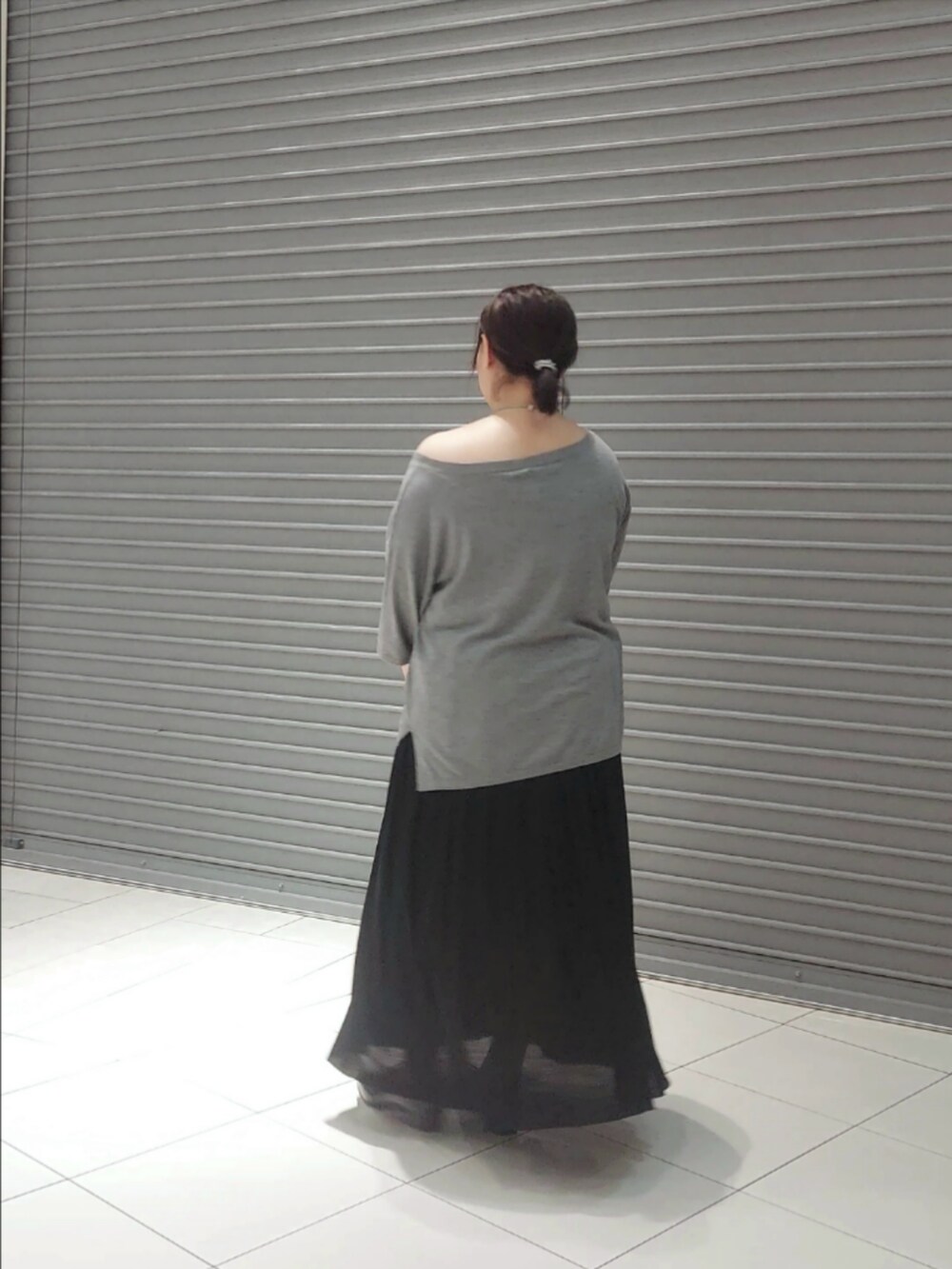 ブラック系のニット/セーター、ブラック系のスカートを着用したレディースの秋コーディネートの2枚目の写真