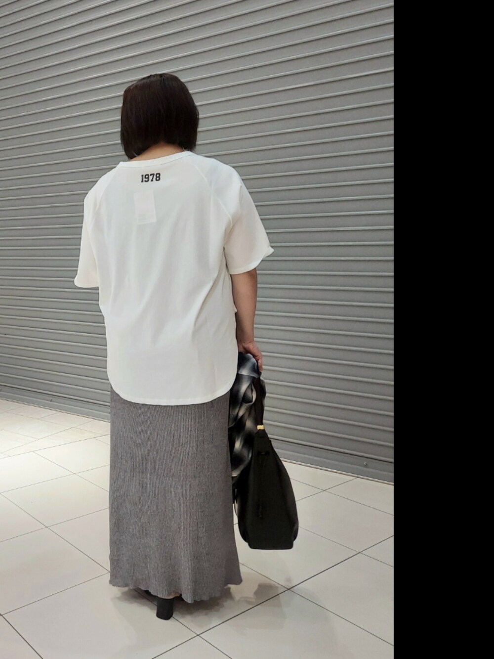 ブラウン系のTシャツ/カットソー、ブルー系のシャツ/ブラウス、グレー系のスカートを着用したレディースの夏コーディネートの2枚目の写真