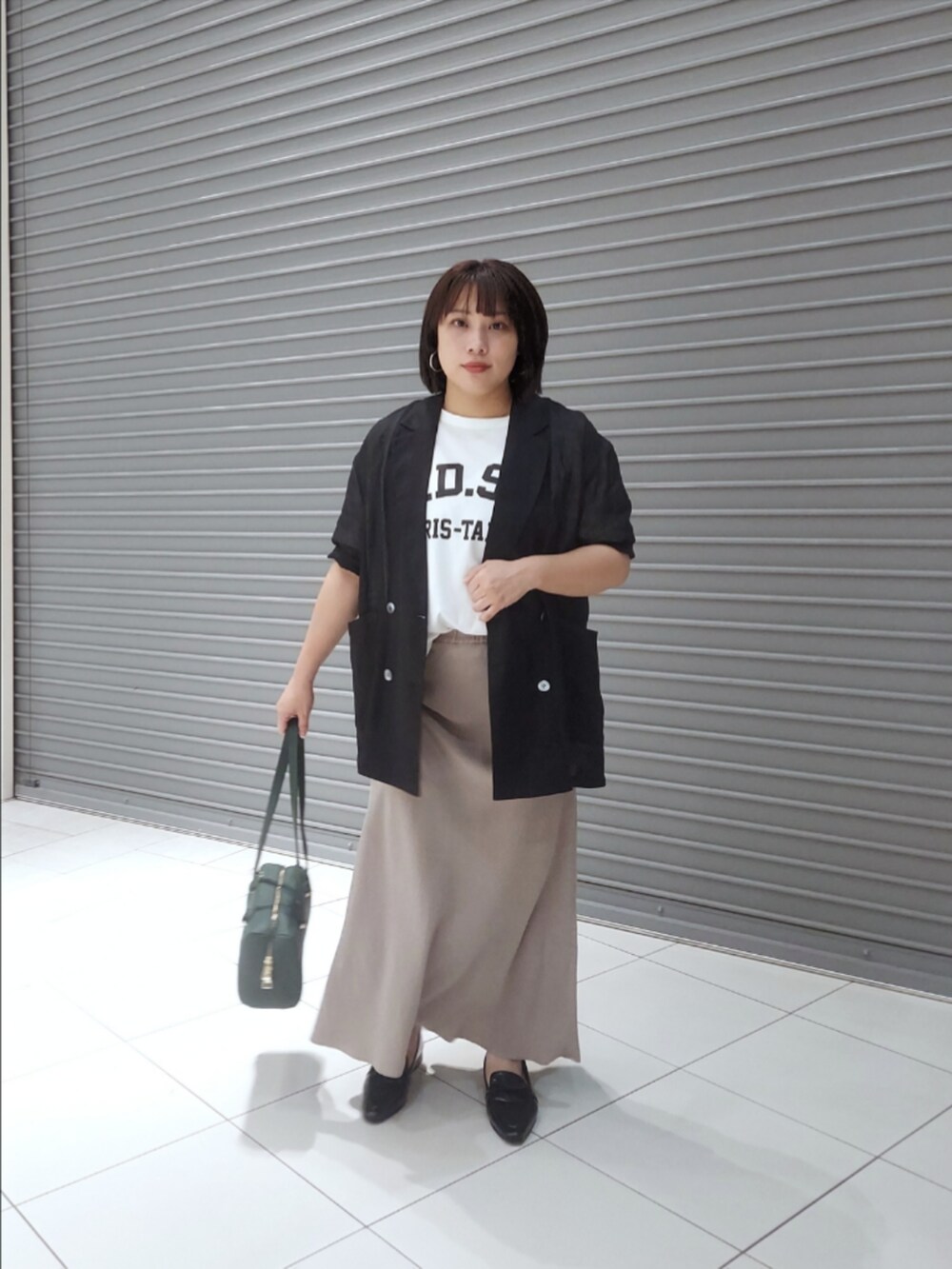 ブラック系のテーラードジャケット、ホワイト系のTシャツ/カットソー、グレー系のスカートを着用したレディースの夏コーディネートの3枚目の写真