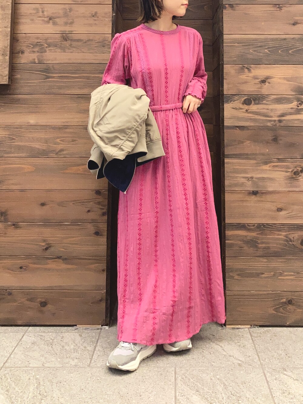 ピンク系のワンピース、ベージュ系のMA-1、グレー系のスニーカーを着用したレディースの秋コーディネートの2枚目の写真