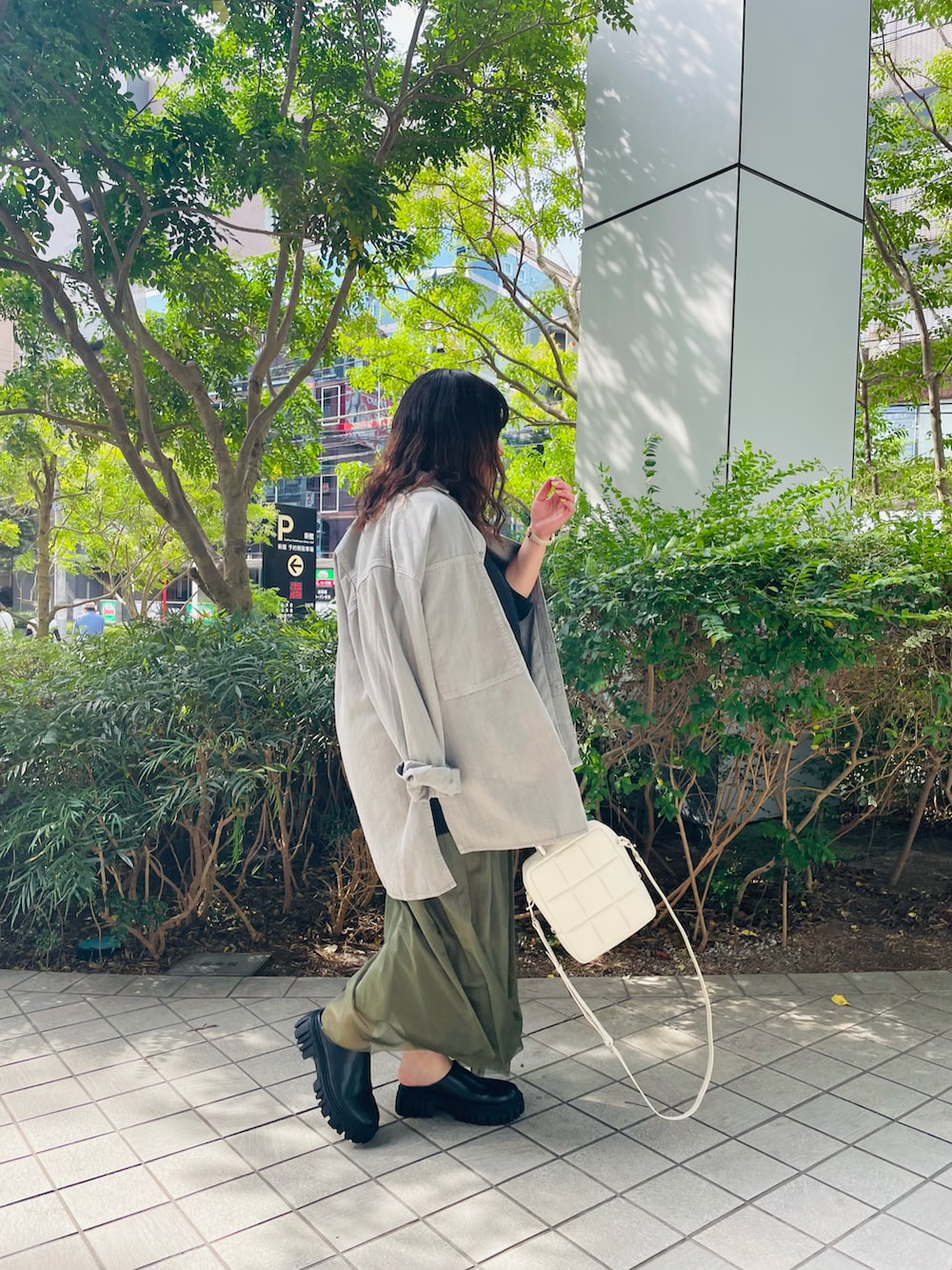 ブラック系のTシャツ/カットソー、グリーン系のスカート、ブラック系のブーツを着用したレディースの夏コーディネートの2枚目の写真