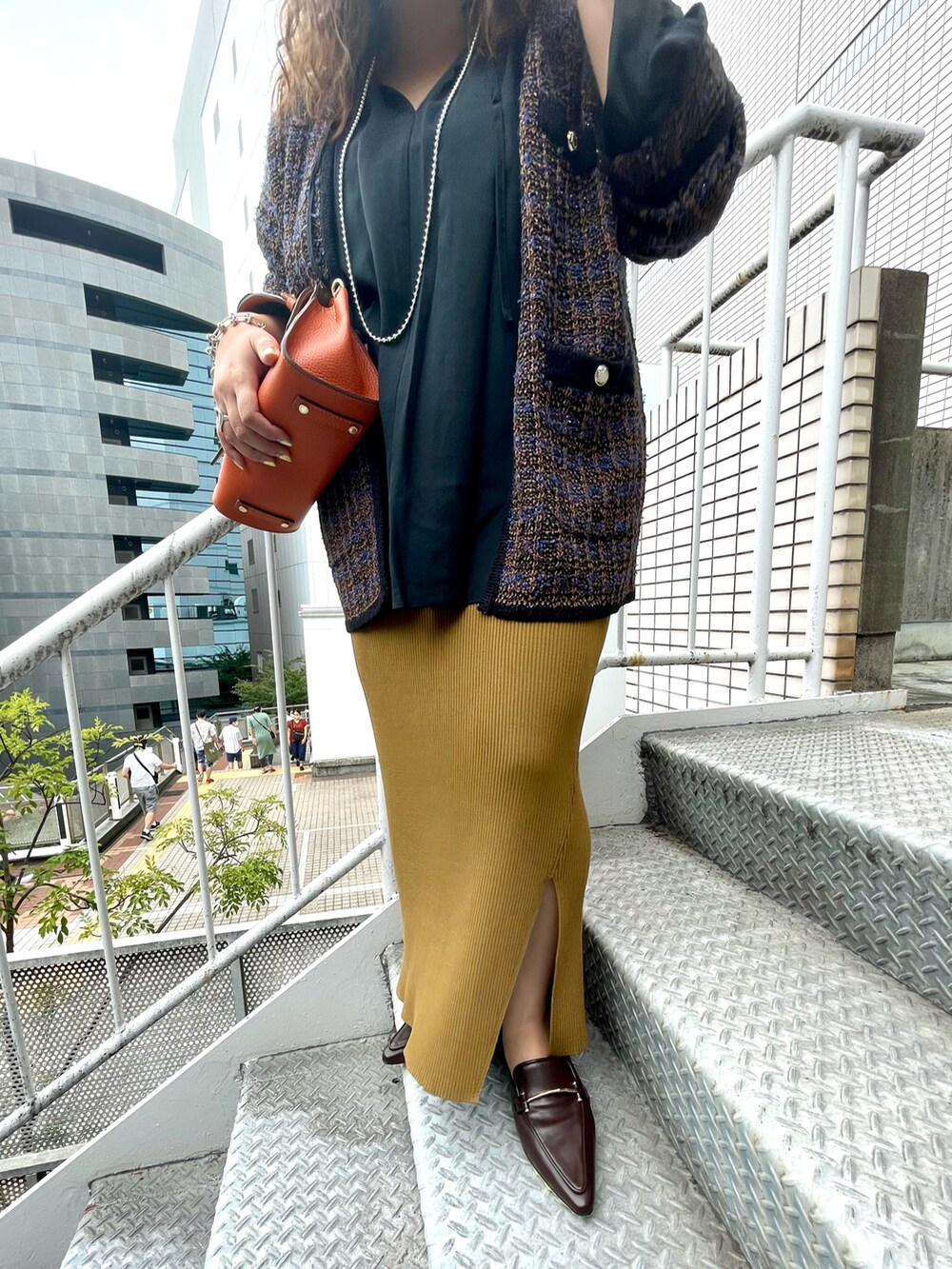 ブラウン系のカーディガン/ボレロ、ブラック系のシャツ/ブラウス、グリーン系のスカートを着用したレディースの夏コーディネートの3枚目の写真