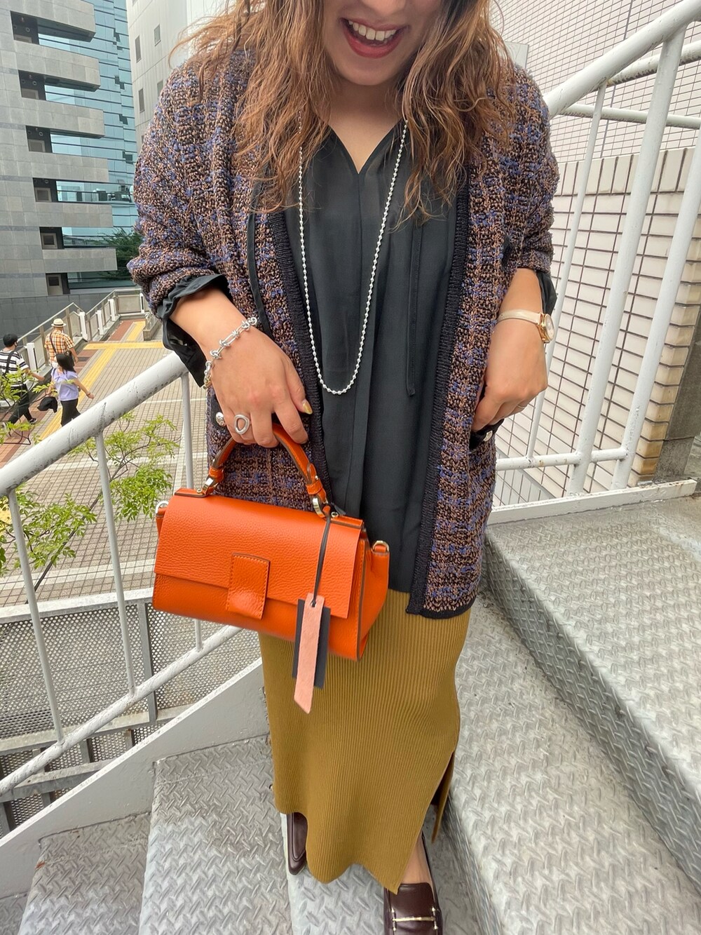 ブラウン系のカーディガン/ボレロ、ブラック系のシャツ/ブラウス、グリーン系のスカートを着用したレディースの夏コーディネートの2枚目の写真