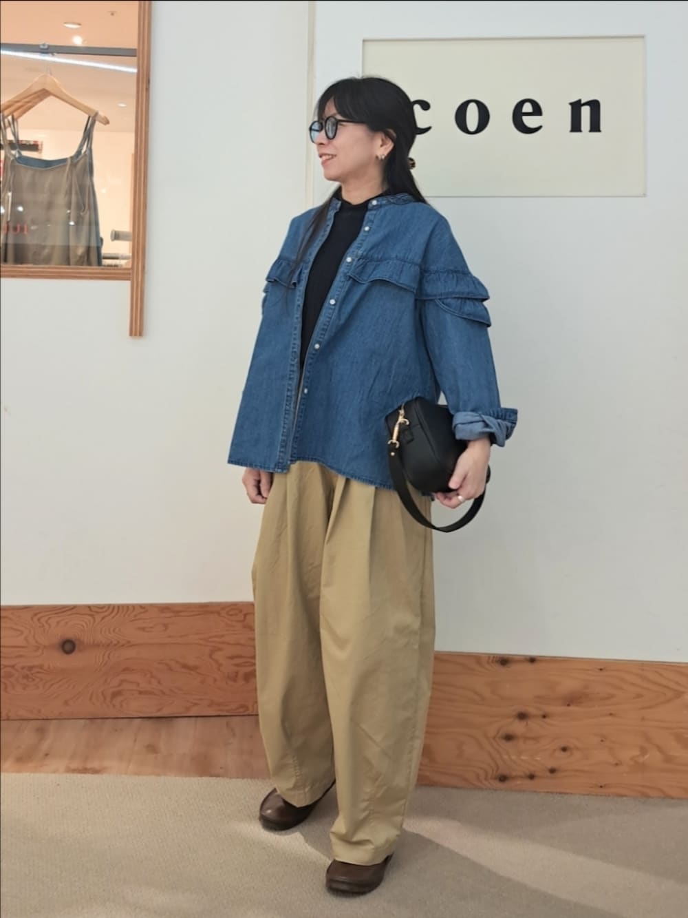 「coen、coenスタッフスタイリング、コーエン、春コーデ、パンツスタイル、大人カジュアル、シャツスタイル、デニム、デニムシャツ、お出かけコーデ、ショルダーバッグ、メガネ女子、休日スタイル、いつもありがとうございます、春のNewスタイル」｜「coenのデニムフリルブラウス（シャツ/ブラウス、ブルー系）」を使った、coenなるせさん（骨格ストレート・レディース・157cm）の春コーディネートの2枚目の写真