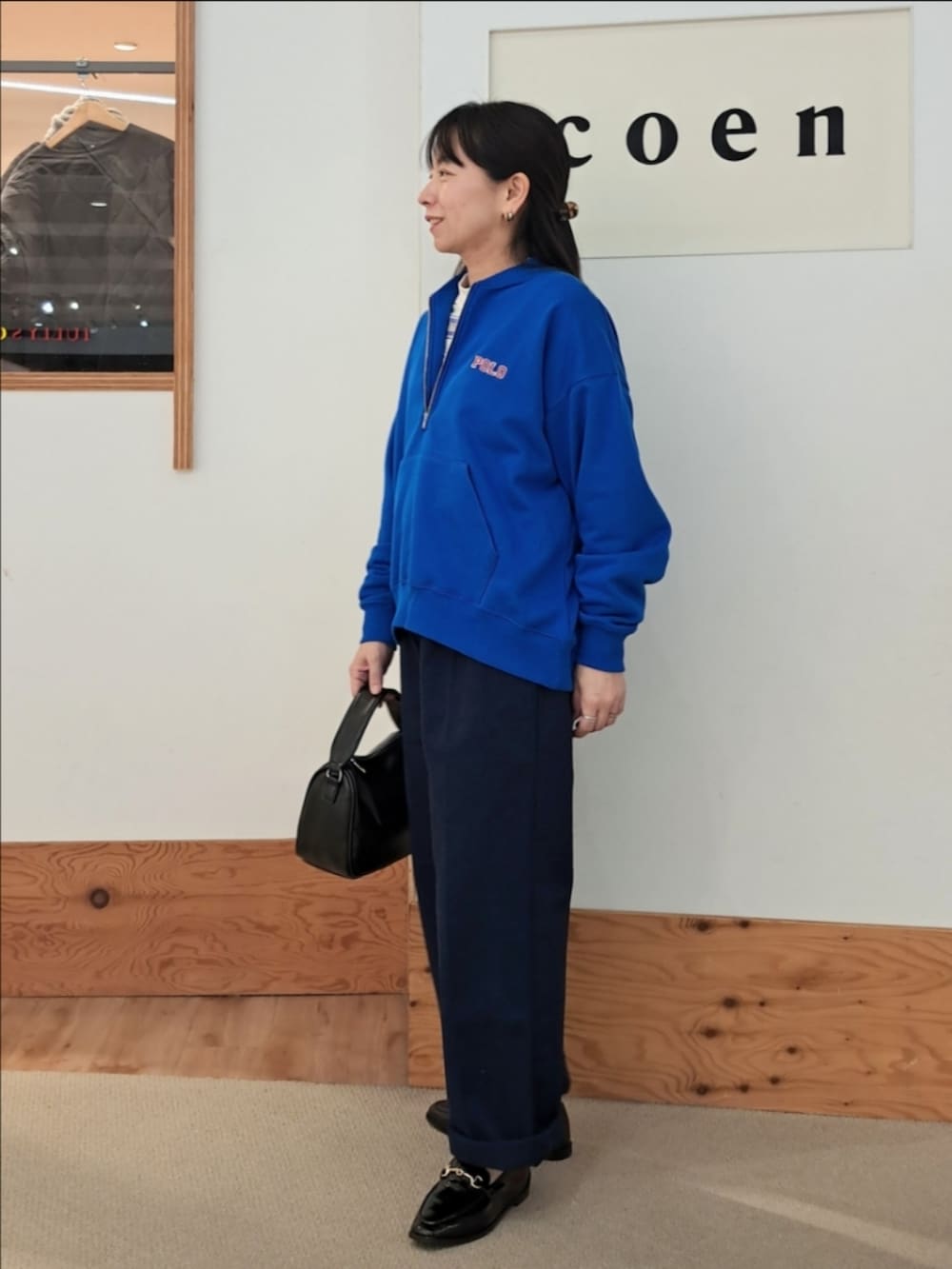 ブルー系のスウェット、ホワイト系のTシャツ/カットソー、ブルー系のチノパンツを着用したレディースの冬コーディネートの2枚目の写真