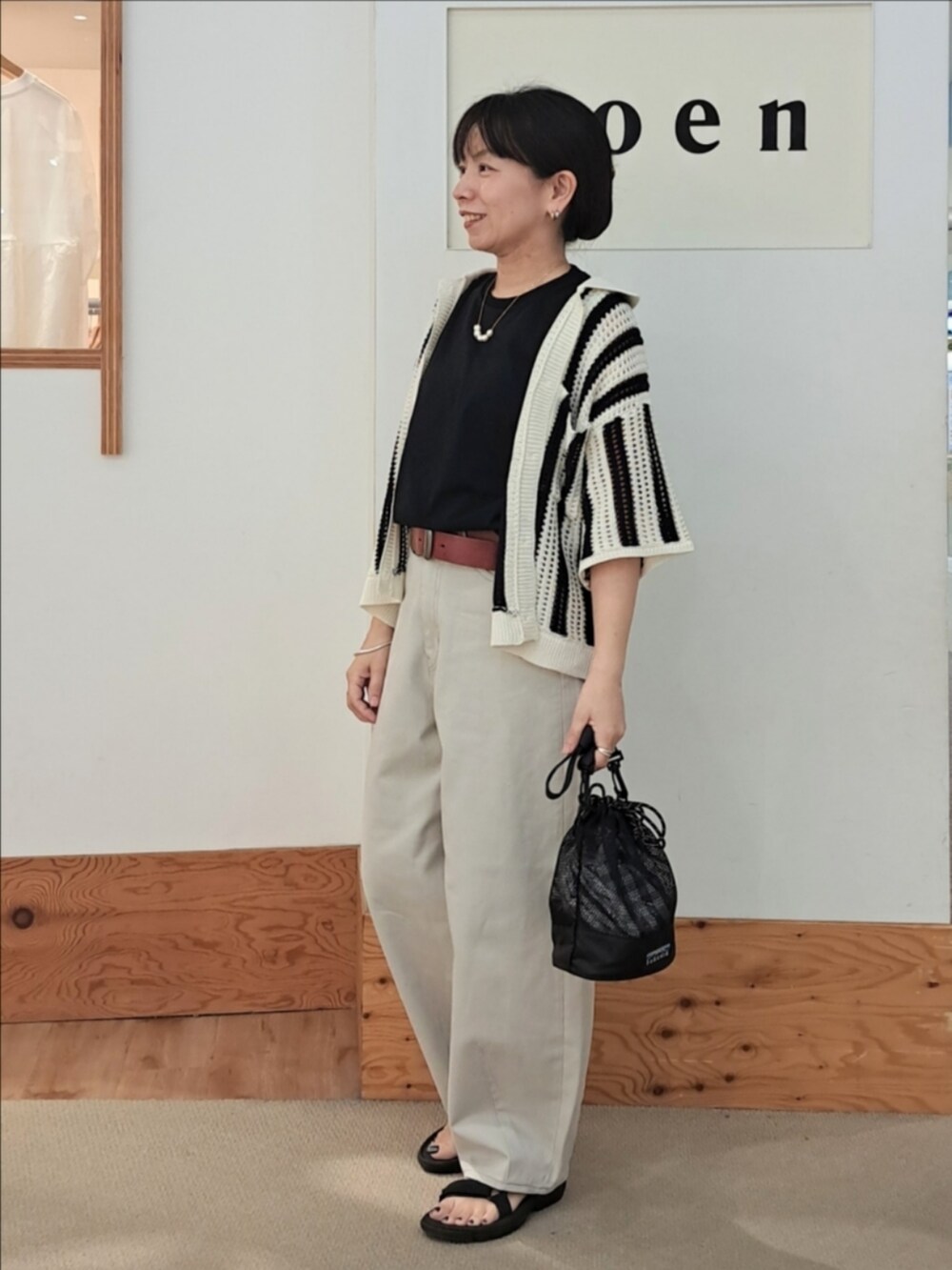 ブラック系のTシャツ/カットソー、グレー系のその他パンツ、その他のショルダーバッグを着用したレディースの春コーディネートの3枚目の写真