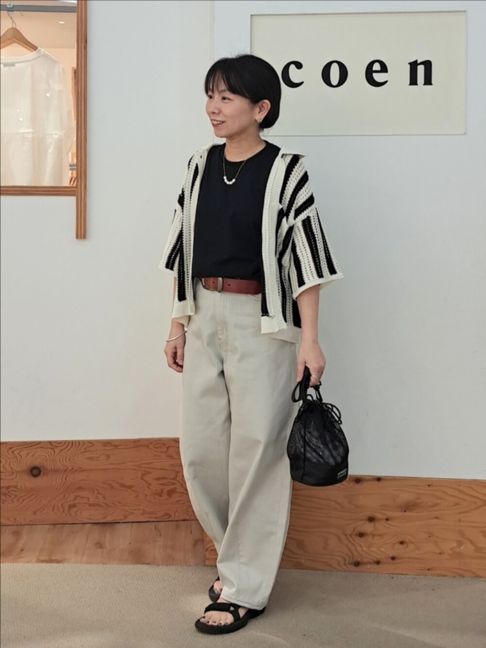 ブラック系のTシャツ/カットソー、グレー系のその他パンツ、その他のショルダーバッグを着用したレディースの春コーディネートの2枚目の写真