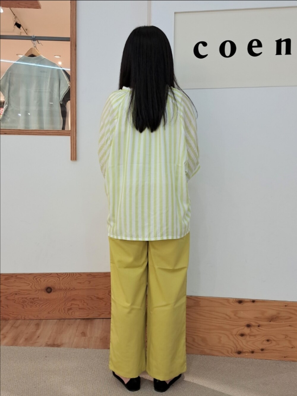 グリーン系のシャツ/ブラウス、イエロー系のスラックス、ホワイト系のタンクトップを着用したレディースの春コーディネートの4枚目の写真