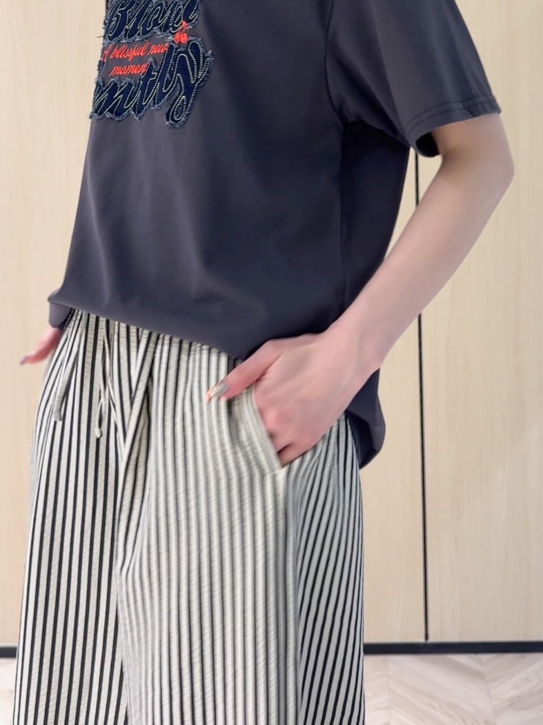 グレー系のTシャツ/カットソー、ホワイト系のその他パンツ、ブラック系のサンダルを着用したレディースの夏コーディネートの5枚目の写真