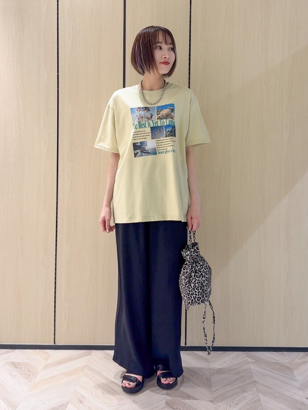 イエロー系のTシャツ/カットソー、ブラック系のサンダル、ベージュ系のショルダーバッグを着用したレディースの夏コーディネートの7枚目の写真