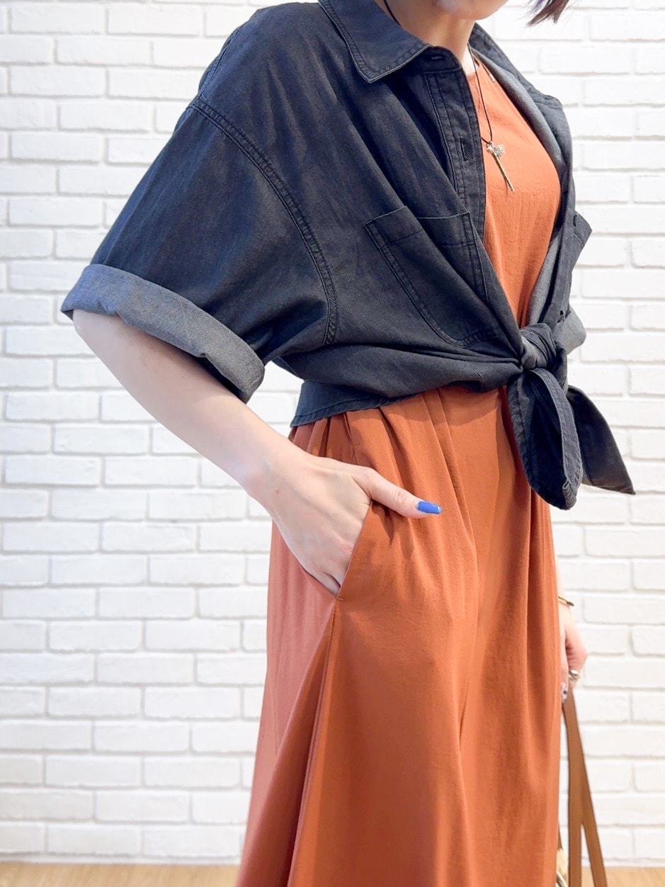 ブラック系のシャツ/ブラウス、オレンジ系のワンピース、ブラック系のサンダルを着用したレディースの夏コーディネートの5枚目の写真