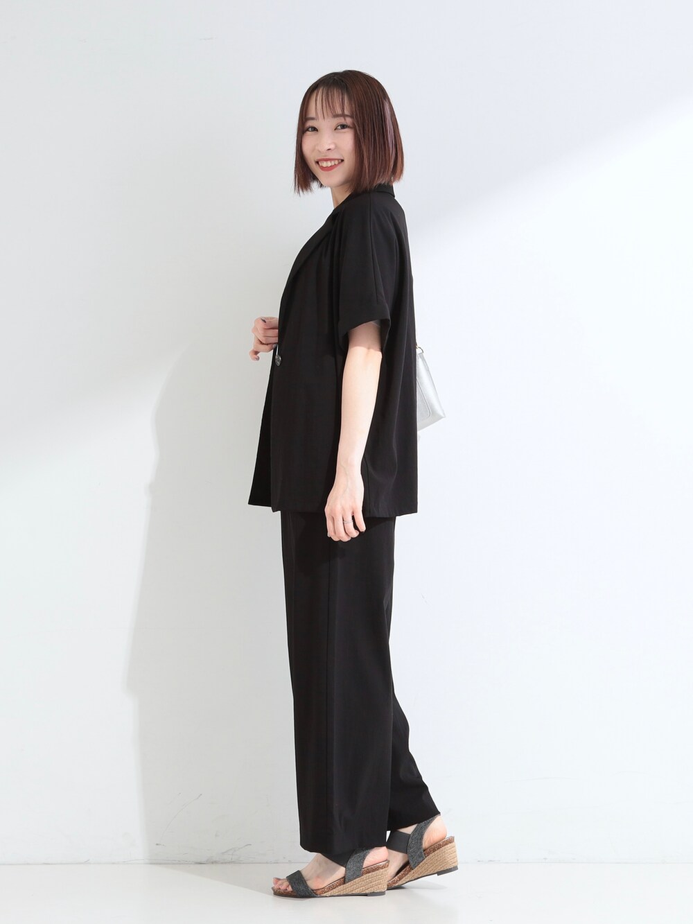 ブラック系のテーラードジャケット、ブルー系のTシャツ/カットソー、ブラック系のその他パンツを着用したレディースの夏コーディネートの4枚目の写真