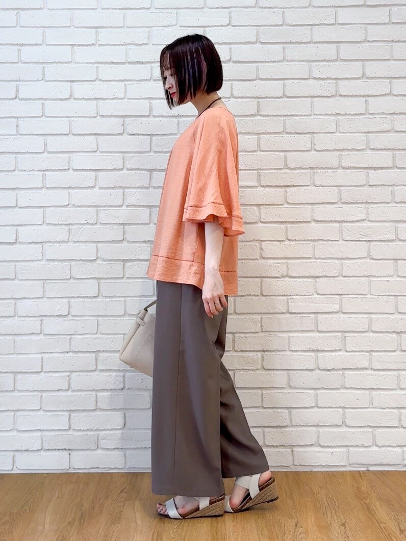 オレンジ系のシャツ/ブラウス、ブラウン系のその他パンツ、ホワイト系のサンダルを着用したレディースの夏コーディネートの4枚目の写真