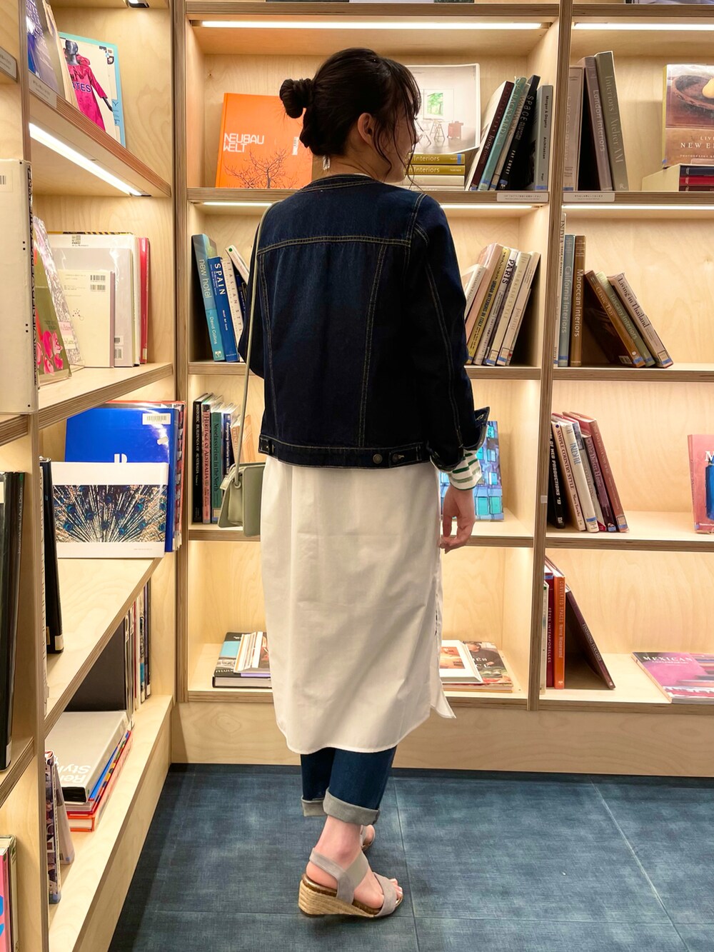 ブルー系のデニムジャケット、ホワイト系のワンピース、ブラック系のTシャツ/カットソーを着用したレディースの春コーディネートの3枚目の写真