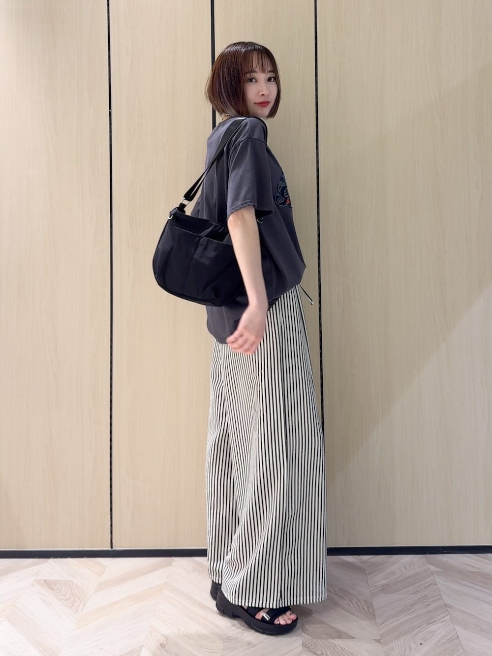 グレー系のTシャツ/カットソー、ホワイト系のその他パンツ、ブラック系のサンダルを着用したレディースの夏コーディネートの2枚目の写真