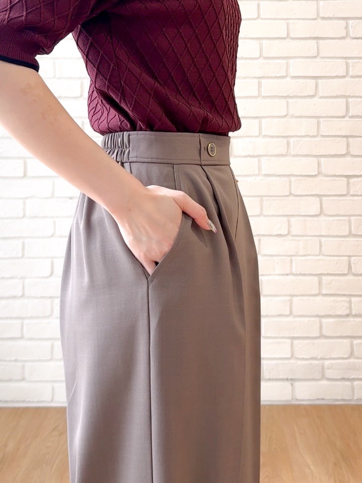 レッド系のニット/セーター、ブラウン系のその他パンツ、ブラック系のショルダーバッグを着用したレディースの夏コーディネートの7枚目の写真
