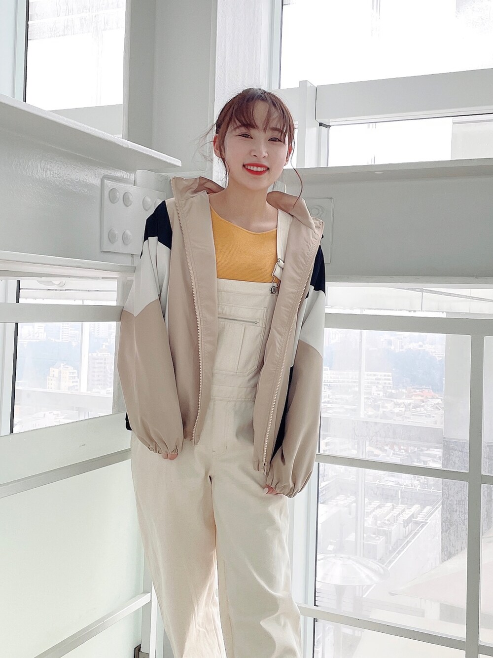 ベージュ系のブルゾン、ホワイト系のサロペット/オーバーオール、イエロー系のニット/セーターを着用したレディースの春コーディネートの3枚目の写真