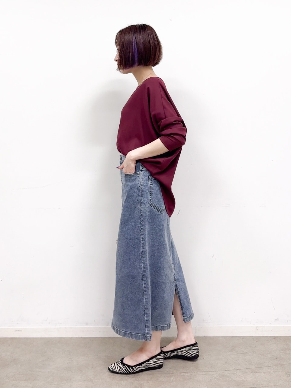 レッド系のシャツ/ブラウス、ブルー系のデニムスカート、ブラック系のパンプスを着用したレディースの秋コーディネートの4枚目の写真