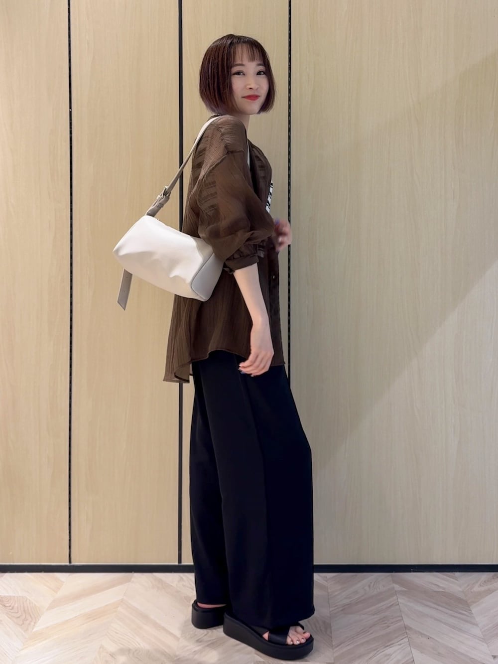 ブラウン系のシャツ/ブラウス、ベージュ系のニット/セーター、ブラック系のその他パンツを着用したレディースの夏コーディネートの2枚目の写真
