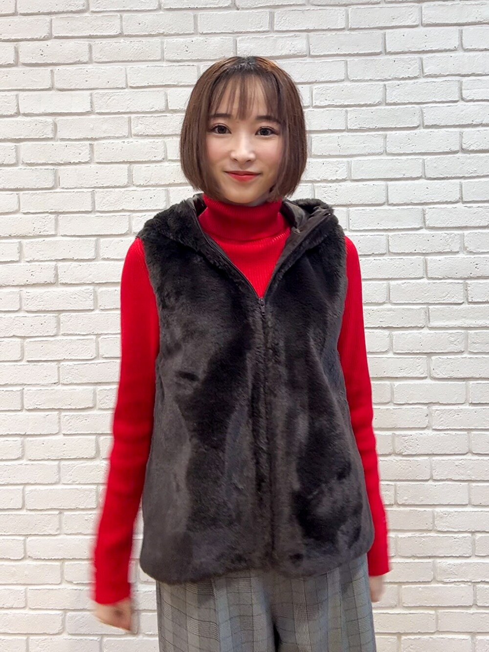 レッド系のニット/セーター、グレー系のその他パンツ、ブラウン系のブーツを着用したレディースの秋コーディネートの6枚目の写真